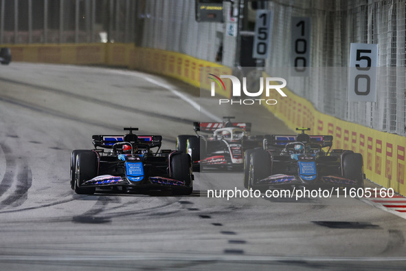 Esteban Ocon of the Alpine F1 Team in action and Pierre Gasly of the Alpine F1 Team in action during the Formula 1 Singapore Grand Prix on t...