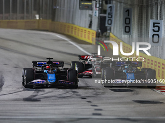 Esteban Ocon of the Alpine F1 Team in action and Pierre Gasly of the Alpine F1 Team in action during the Formula 1 Singapore Grand Prix on t...