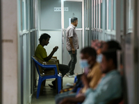 An infected patient uses a mobile phone as he waits for his turn at the Fever Clinic of Sukraraj Tropical and Infectious Disease Hospital in...