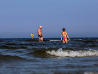 A tourist is seen taking a bath in Autumn cold water of Baltic Sea on a sand beach near Leba, famous pomeranian tourist resort in northern P...