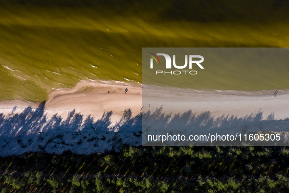 An aerial view of a beach, Baltic Sea and a forest late near Leba, famous pomeranian tourist resort in northern Poland as Autumn begins on S...