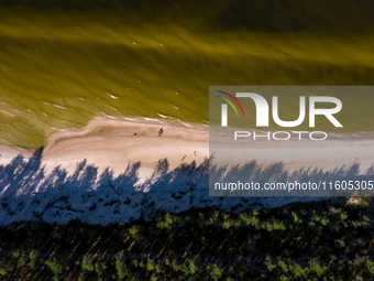 An aerial view of a beach, Baltic Sea and a forest late near Leba, famous pomeranian tourist resort in northern Poland as Autumn begins on S...