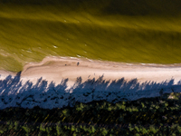 An aerial view of a beach, Baltic Sea and a forest late near Leba, famous pomeranian tourist resort in northern Poland as Autumn begins on S...