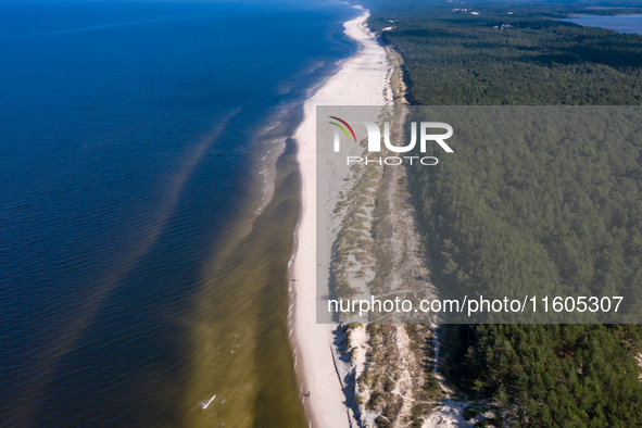 An aerial view of a beach, Baltic Sea and a forest late near Leba, famous pomeranian tourist resort in northern Poland as Autumn begins on S...