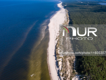 An aerial view of a beach, Baltic Sea and a forest late near Leba, famous pomeranian tourist resort in northern Poland as Autumn begins on S...