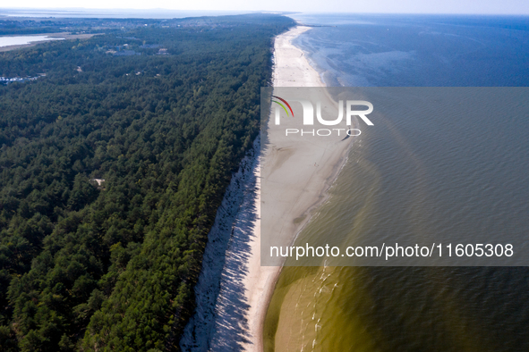 An aerial view of a beach, Baltic Sea and a forest late near Leba, famous pomeranian tourist resort in northern Poland as Autumn begins on S...