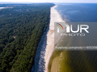 An aerial view of a beach, Baltic Sea and a forest late near Leba, famous pomeranian tourist resort in northern Poland as Autumn begins on S...