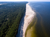 An aerial view of a beach, Baltic Sea and a forest late near Leba, famous pomeranian tourist resort in northern Poland as Autumn begins on S...