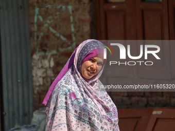 A woman looks on as polling officials and Indian policemen walk in the interiors of Dal Lake towards their designated polling station after...