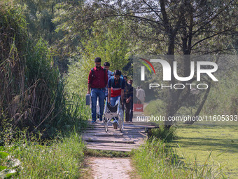 Polling officials walk in the interiors of Dal Lake towards their designated polling station after collecting election materials at a distri...