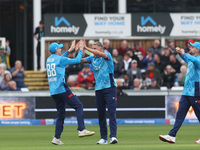 Brydon Carse of England celebrates with Harry Brook after catching Australia's Mitchell Marsh behind the wicket during the Metro Bank One Da...