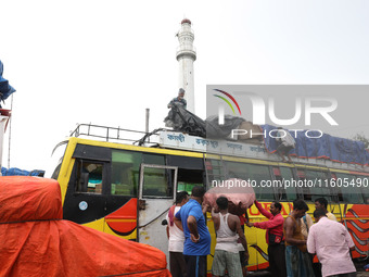 Labourers load consumer goods onto a passenger bus after it arrives from a neighboring state at a bus terminal in Kolkata, India, on Septemb...