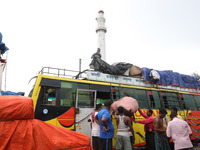 Labourers load consumer goods onto a passenger bus after it arrives from a neighboring state at a bus terminal in Kolkata, India, on Septemb...