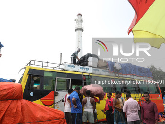 Labourers load consumer goods onto a passenger bus after it arrives from a neighboring state at a bus terminal in Kolkata, India, on Septemb...