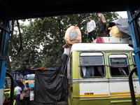 Labourers load consumer goods onto a passenger bus after it arrives from a neighboring state at a bus terminal in Kolkata, India, on Septemb...