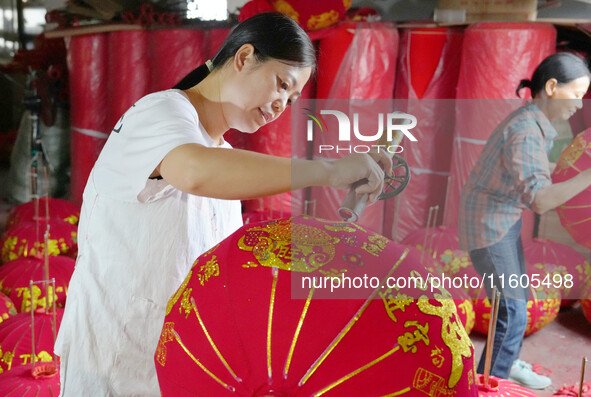 A worker makes red lanterns at a lantern processing workshop in Hai'an, China, on September 24, 2024. 