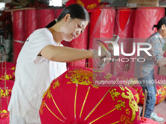 A worker makes red lanterns at a lantern processing workshop in Hai'an, China, on September 24, 2024. (