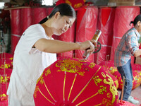 A worker makes red lanterns at a lantern processing workshop in Hai'an, China, on September 24, 2024. (