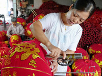 A worker makes red lanterns at a lantern processing workshop in Hai'an, China, on September 24, 2024. (