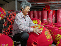 A worker makes red lanterns at a lantern processing workshop in Hai'an, China, on September 24, 2024. (