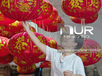 A worker makes red lanterns at a lantern processing workshop in Hai'an, China, on September 24, 2024. (