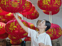 A worker makes red lanterns at a lantern processing workshop in Hai'an, China, on September 24, 2024. (