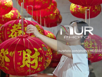 A worker makes red lanterns at a lantern processing workshop in Hai'an, China, on September 24, 2024. (