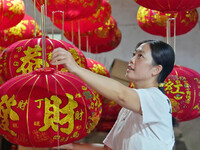 A worker makes red lanterns at a lantern processing workshop in Hai'an, China, on September 24, 2024. (