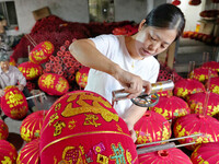 A worker makes red lanterns at a lantern processing workshop in Hai'an, China, on September 24, 2024. (