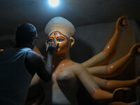 Artists paint the eyes of an idol of Goddess Durga, known as ''Chokhhu Daan,'' at a potters' hub ahead of the Durga Puja festival in Kolkata...