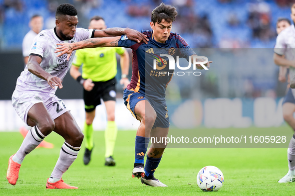 Christian Kabasele of Udinese Calcio and Paulo Dybala of AS Roma compete for the ball during the Serie A Enilive match between AS Roma and U...