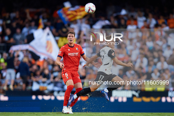 Dani Gomez (L) of Valencia CF competes for the ball with Herrando of CA Osasuna during the LaLiga EA Sports match between Valencia CF and CA...