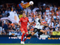 Dani Gomez (L) of Valencia CF competes for the ball with Herrando of CA Osasuna during the LaLiga EA Sports match between Valencia CF and CA...