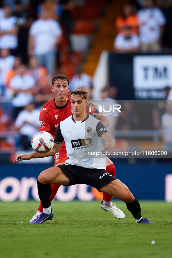 Dani Gomez (R) of Valencia CF competes for the ball with Herrando of CA Osasuna during the LaLiga EA Sports match between Valencia CF and CA...