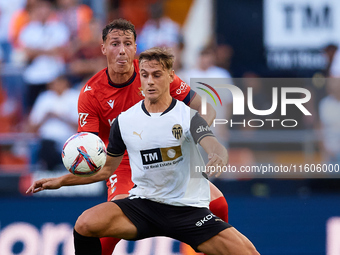 Dani Gomez (R) of Valencia CF competes for the ball with Herrando of CA Osasuna during the LaLiga EA Sports match between Valencia CF and CA...