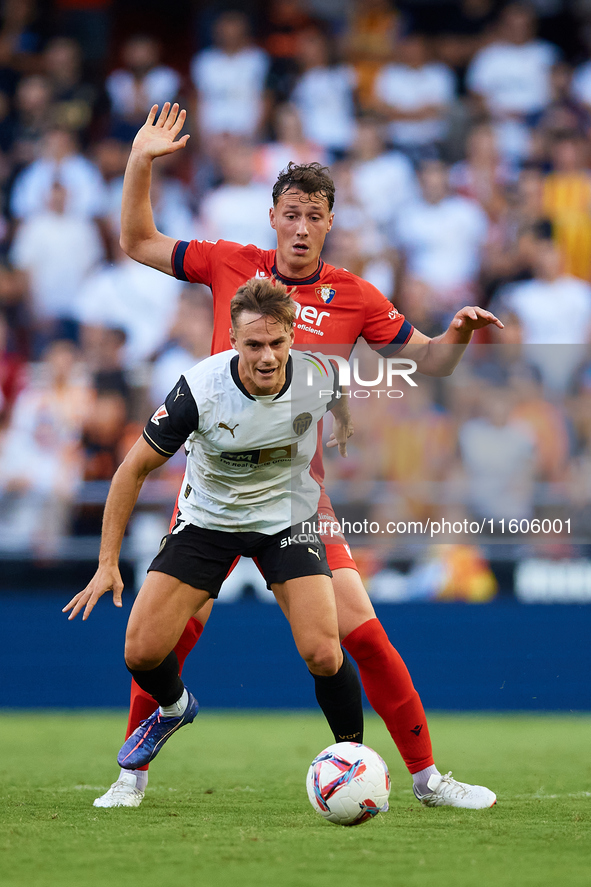 Dani Gomez (L) of Valencia CF competes for the ball with Herrando of CA Osasuna during the LaLiga EA Sports match between Valencia CF and CA...