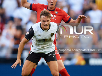 Dani Gomez (L) of Valencia CF competes for the ball with Herrando of CA Osasuna during the LaLiga EA Sports match between Valencia CF and CA...