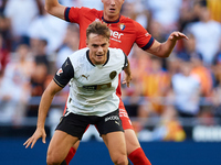 Dani Gomez (L) of Valencia CF competes for the ball with Herrando of CA Osasuna during the LaLiga EA Sports match between Valencia CF and CA...