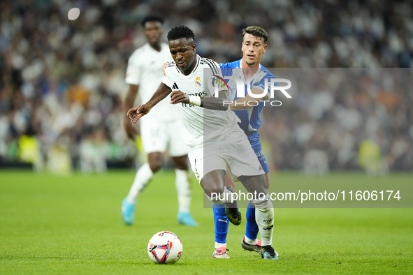 Vinicius Junior left winger of Real Madrid and Brazil and Antonio Blanco defensive midfield of Alaves and Spain compete for the ball during...