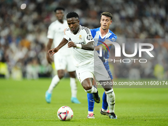 Vinicius Junior left winger of Real Madrid and Brazil and Antonio Blanco defensive midfield of Alaves and Spain compete for the ball during...