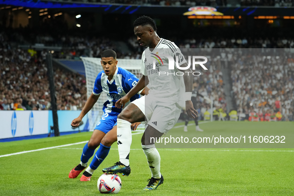 Vinicius Junior left winger of Real Madrid and Brazil and Santiago Mouriño centre-back of Alaves and Uruguay compete for the ball during the...