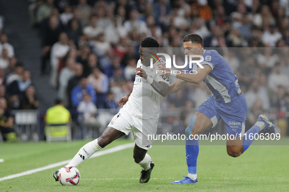 Vinicius Jr of Real Madrid and Abdelkabir Abqar of Alaves during the La Liga 2024/25 match between Real Madrid and Alaves at Santiago Bernab...