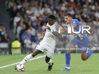 Vinicius Jr of Real Madrid and Abdelkabir Abqar of Alaves during the La Liga 2024/25 match between Real Madrid and Alaves at Santiago Bernab...