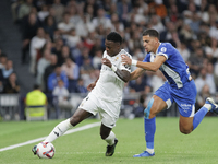 Vinicius Jr of Real Madrid and Abdelkabir Abqar of Alaves during the La Liga 2024/25 match between Real Madrid and Alaves at Santiago Bernab...