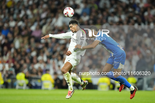 Jude Bellingham central midfield of Real Madrid and England and Santiago Mouriño centre-back of Alaves and Uruguay compete for the ball duri...