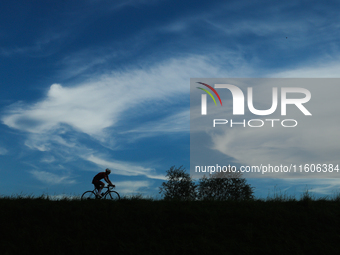 A Cyclist rides the flood embankment in Krakow, Poland on September 23, 2024. (