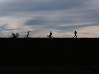 Cyclist and runner are seen at the flood embankment in Krakow, Poland on September 23, 2024. (