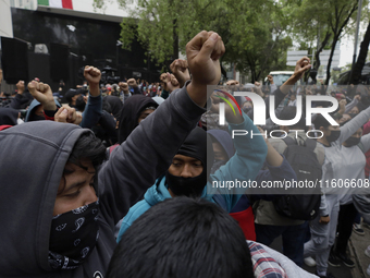 The 43 missing students from Ayotzinapa throw firecrackers on Tuesday, September 24, 2024, and demonstrate outside the Senate of the Republi...