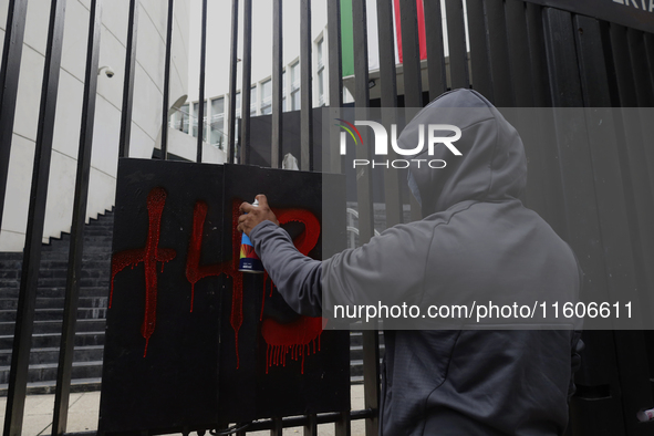 The 43 missing students of Ayotzinapa paint graffiti outside the Senate of the Republic in Mexico City, Mexico, on September 24, 2024, to de...