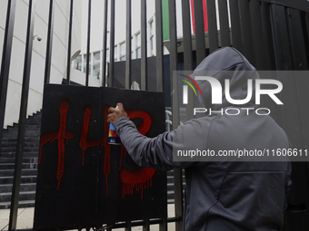 The 43 missing students of Ayotzinapa paint graffiti outside the Senate of the Republic in Mexico City, Mexico, on September 24, 2024, to de...